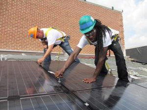 Workers install rooftop solar panels in Illinois