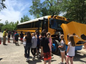 Students stand near an electric school bus in Chicago, 2019