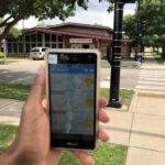 hand holding a phone shows air monitor data