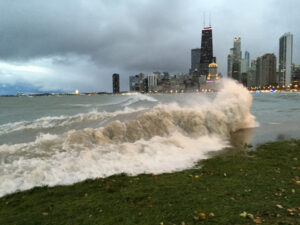 High waves crash against the shore with the Chicago skyline in the background