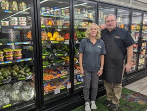 Rhonda and Brian Peterson stand in front of their new energy efficient refrigerators at Fiesta Foods rural grocery store