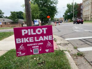 Pink sign indicates a pilot bike lane in Kalamazoo Michigan