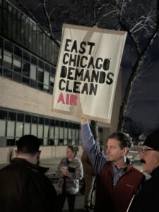 A man holds a poster saying "East Chicago Demands Clean Air" at the IDEM community meeting about BP Whiting refinery's air permit