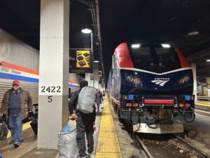 Passengers carry luggage along the platform between two Amtrak Midwest trains at Chicago's Union Station