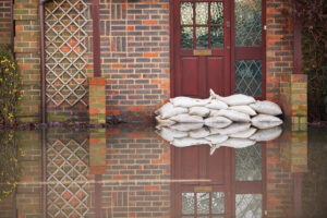 Sandbags Outside Front Door Of Flooded Brick House