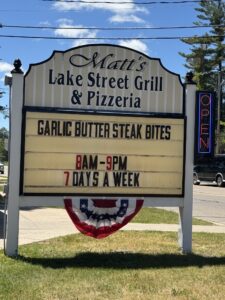 Sign for Matt's Lake Street Grill and Pizzeria in Roscommon Michigan, which has Garlic Butter Steak Bites and is open 8am to 9pm